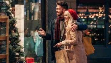 Couple happily looking at store window during the holidays